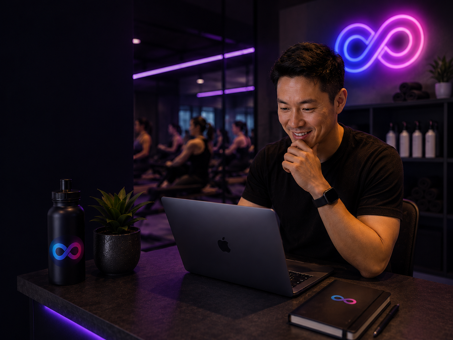 Boutique gym owner reviewing Loop analytics on a laptop with a spin class in the background